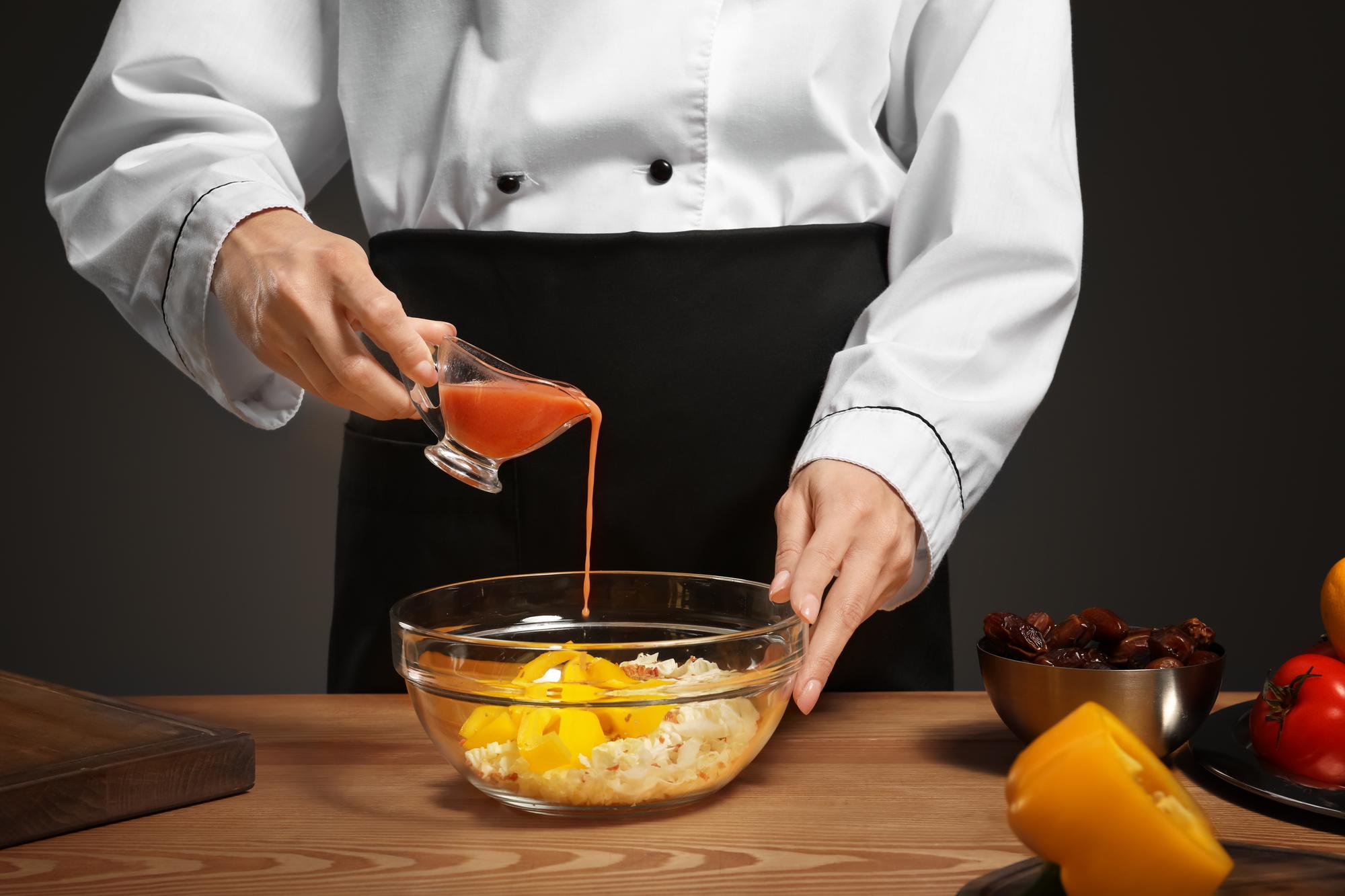 Chef che prepara una salsa raffinata in cucina di lusso